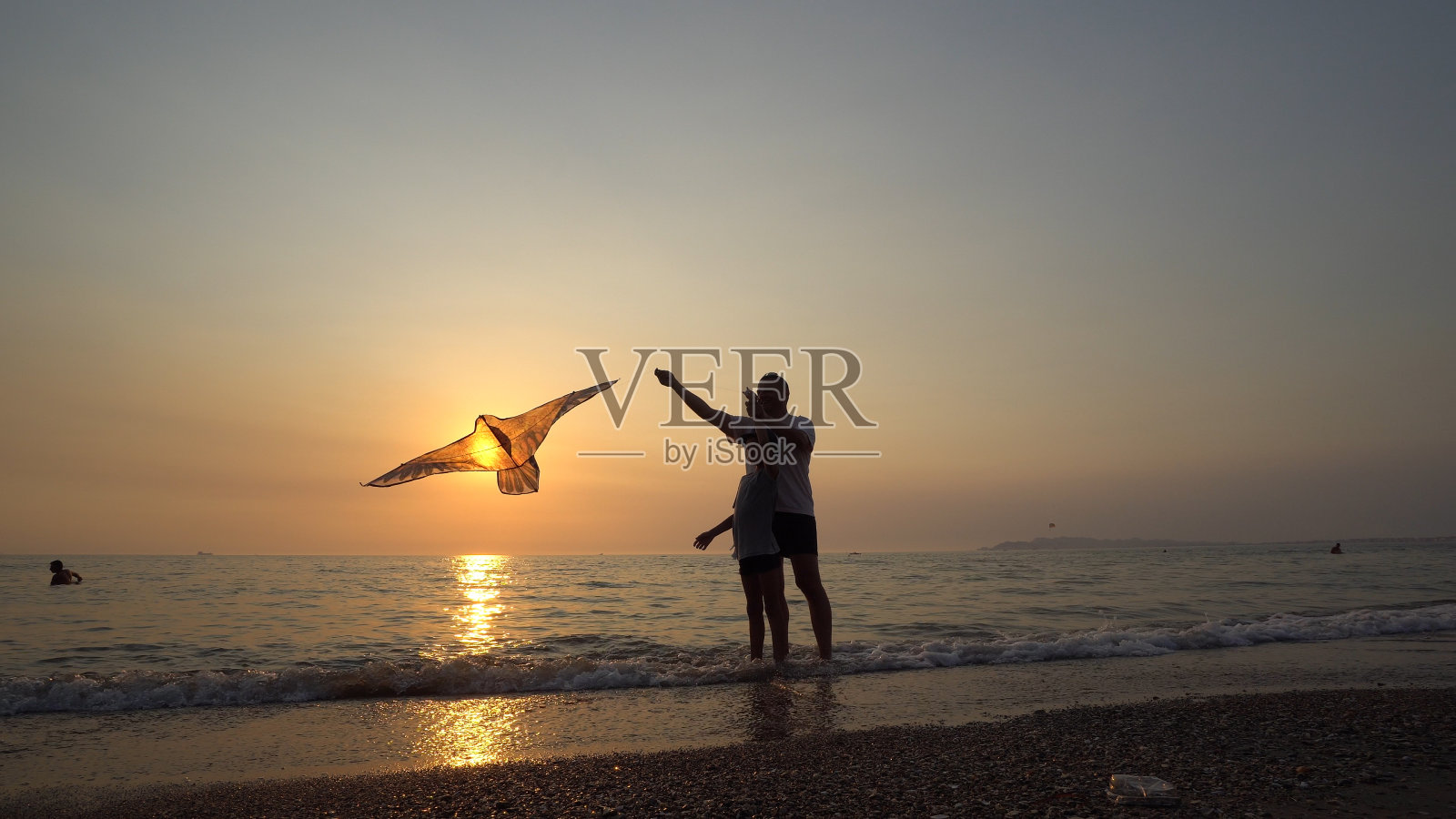 一个小男孩和爸爸在夕阳下玩放风筝，概念暑假照片摄影图片