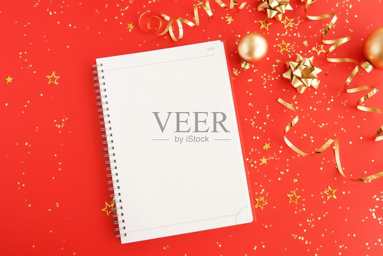 圣诞节或新年的框架装饰在金色和笔记本在红色的背景与空白的文本复制空间。明信片或邀请的圣诞节，假日和庆祝概念。俯视图照片摄影图片