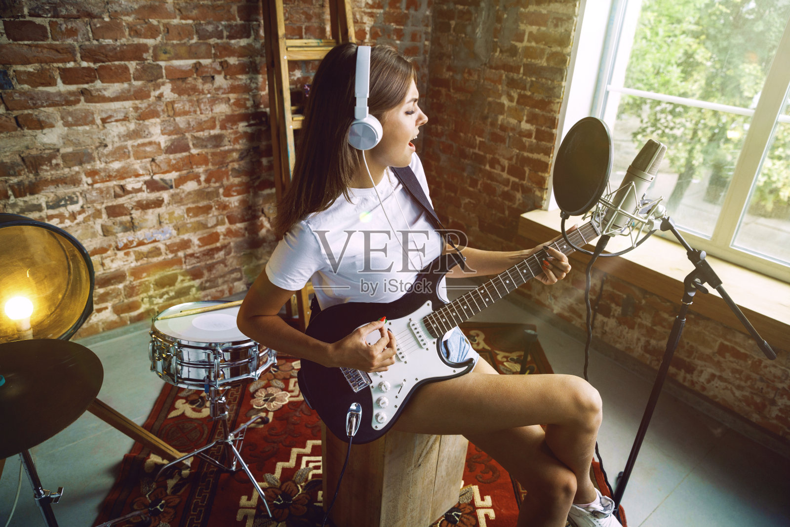 录音，弹吉他，在家唱歌的女人照片摄影图片