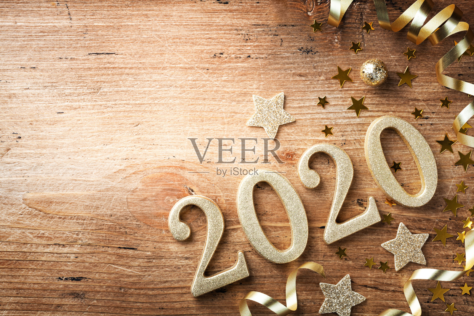 快乐的新年节日背景与金色数字2020和圣诞装饰在古董木制桌顶视图。照片摄影图片