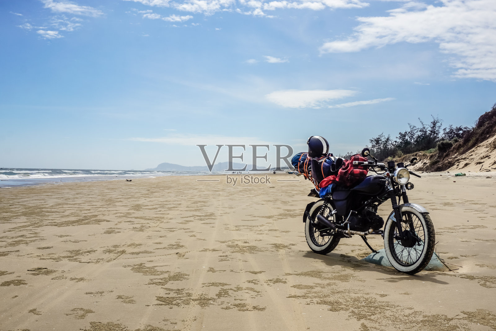 越南摩托车之旅。在云头的野生海滩上骑摩托车照片摄影图片