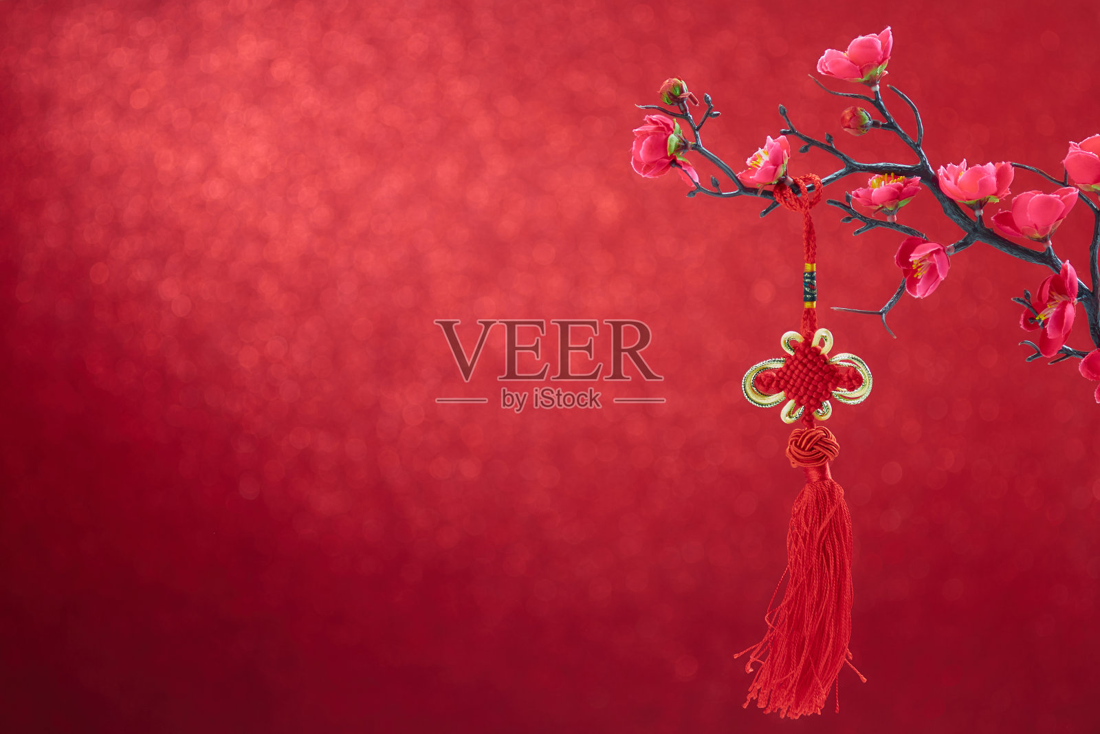 中国新年装饰花梅花与中国结在红色的散克背景照片摄影图片