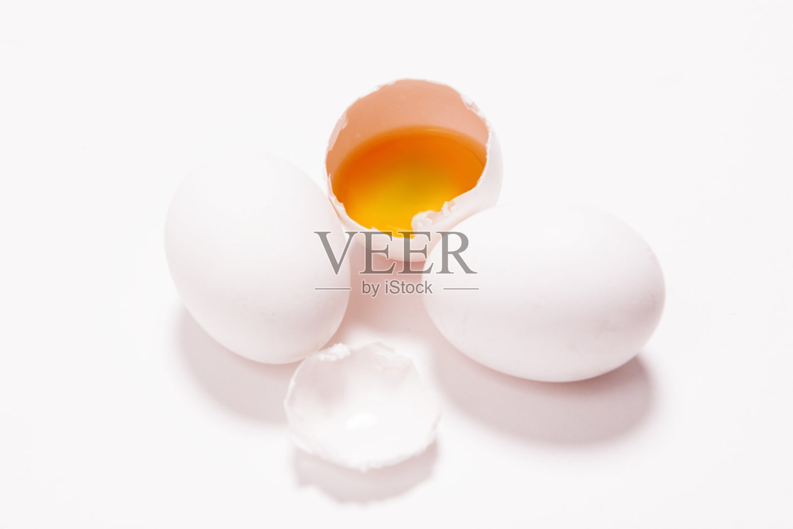 高角度的小组白色生鸡蛋，一个是破在白色的背景照片摄影图片