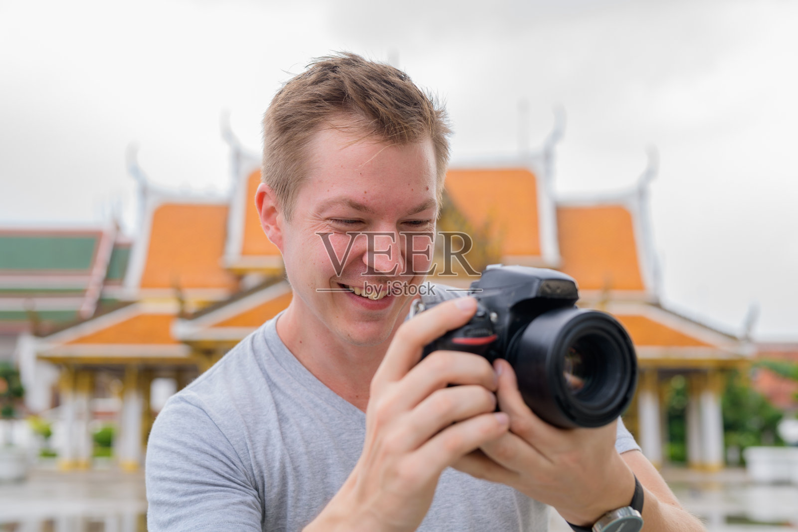 一名快乐的游客在曼谷的佛教寺庙前用相机拍照照片摄影图片