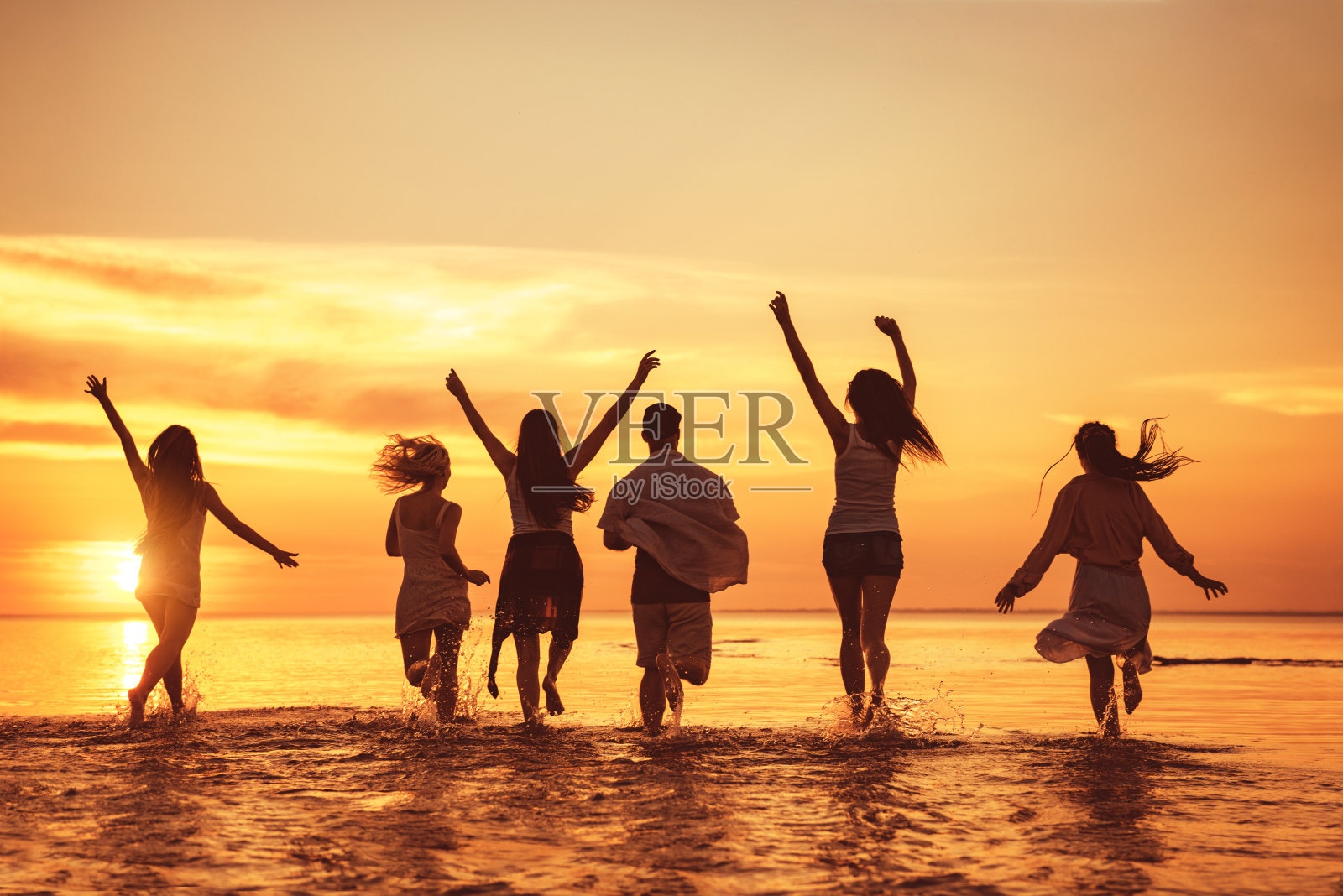 一大群快乐的朋友在日落海滩派对照片摄影图片