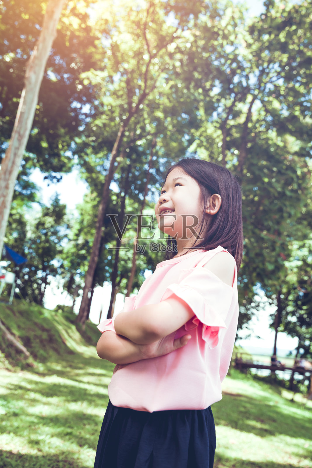 一个在公园里微笑的亚洲小女孩的肖像。照片摄影图片