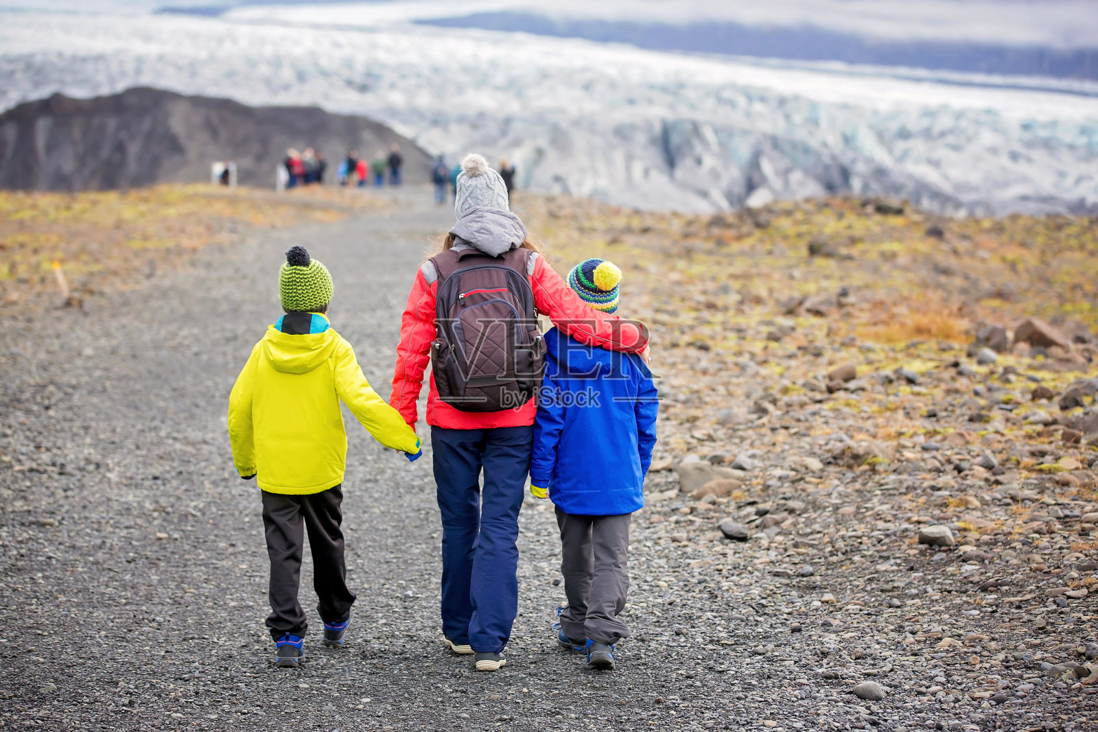 在冰岛一个美丽的秋日，母亲和他的孩子们在通往斯卡夫塔费尔冰川国家公园的小路上散步照片摄影图片