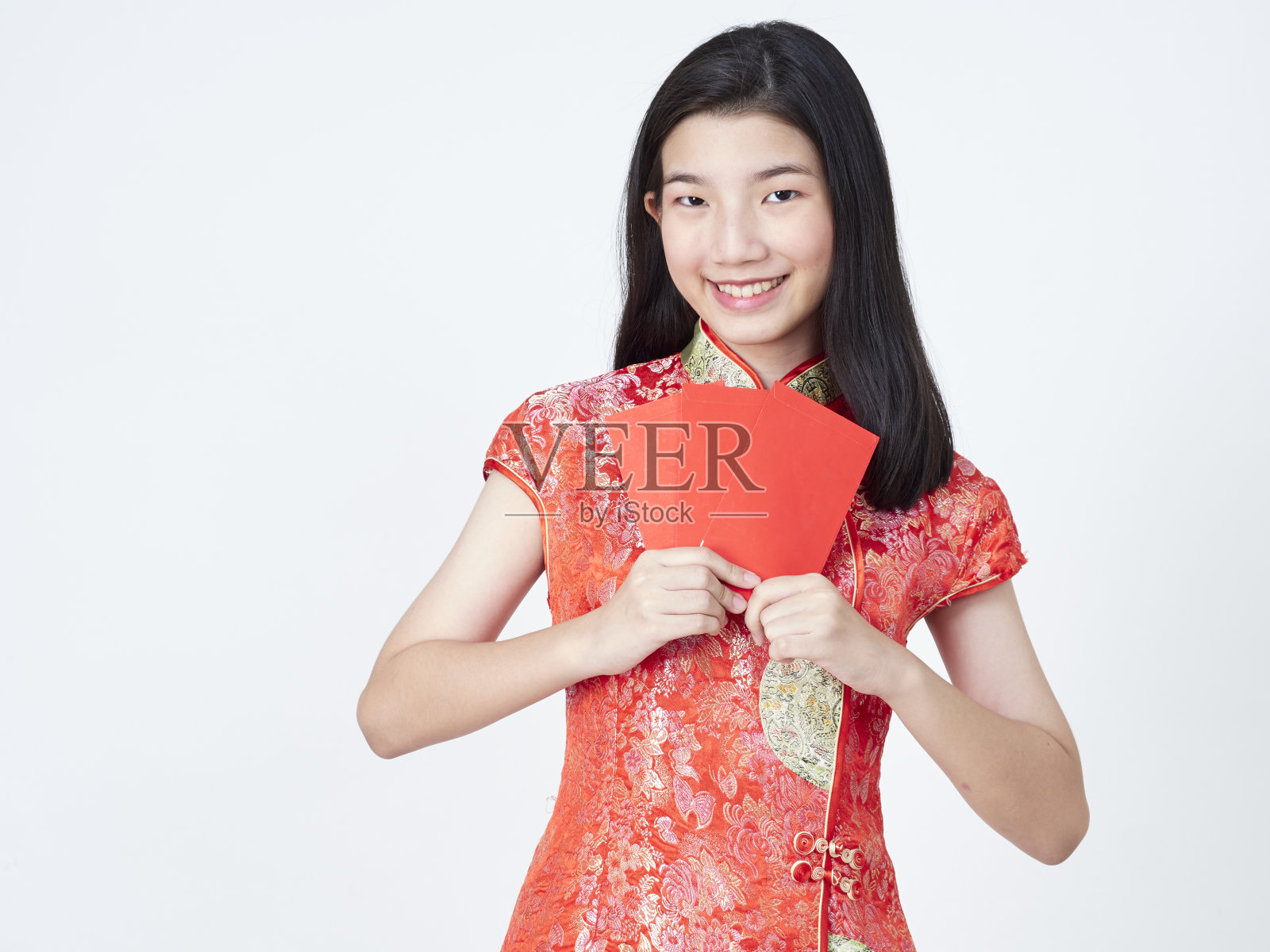 2020年中国新年。身着中国传统旗袍的年轻女子手持白色背景上的红包照片摄影图片