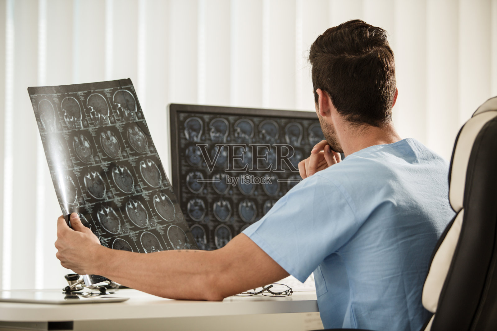 神经外科医生分析脑肿瘤x射线扫描的后视图照片摄影图片