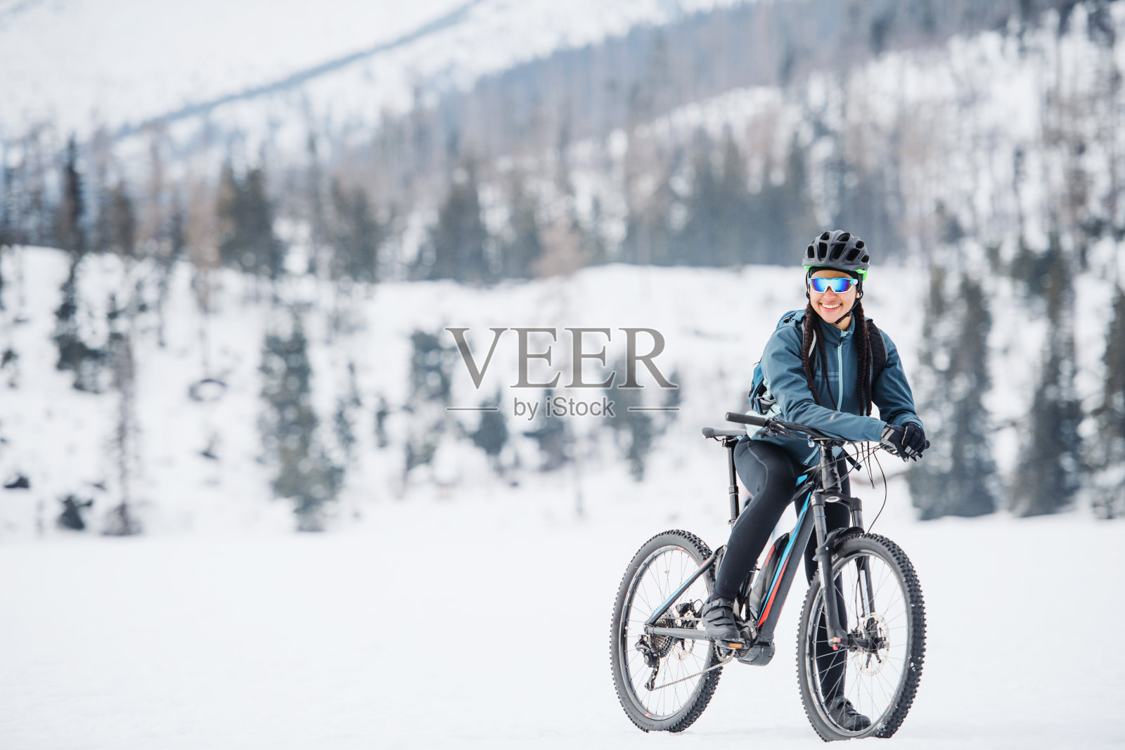 女性山地自行车站在户外在冬天的自然。照片摄影图片