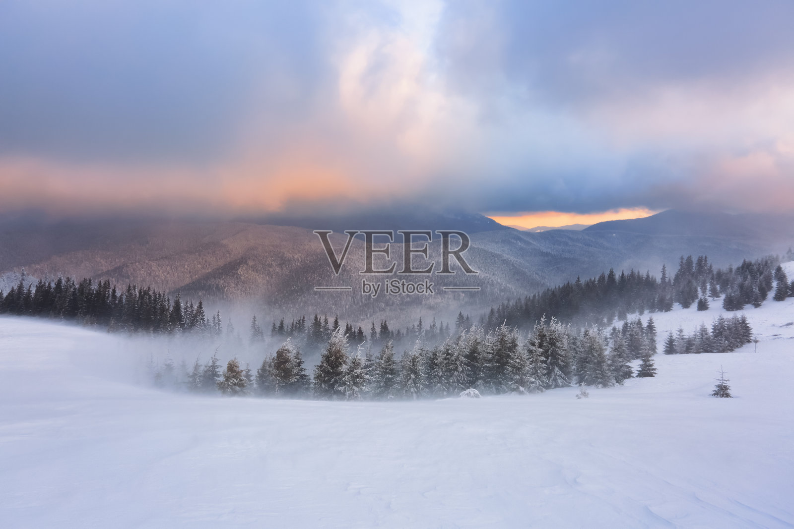 奇妙的日出照亮了高山、森林和地平线。下雪的冬天的早晨。令人惊奇的天空和橙色的云。壁纸背景。地点:欧洲，乌克兰，喀尔巴阡。照片摄影图片