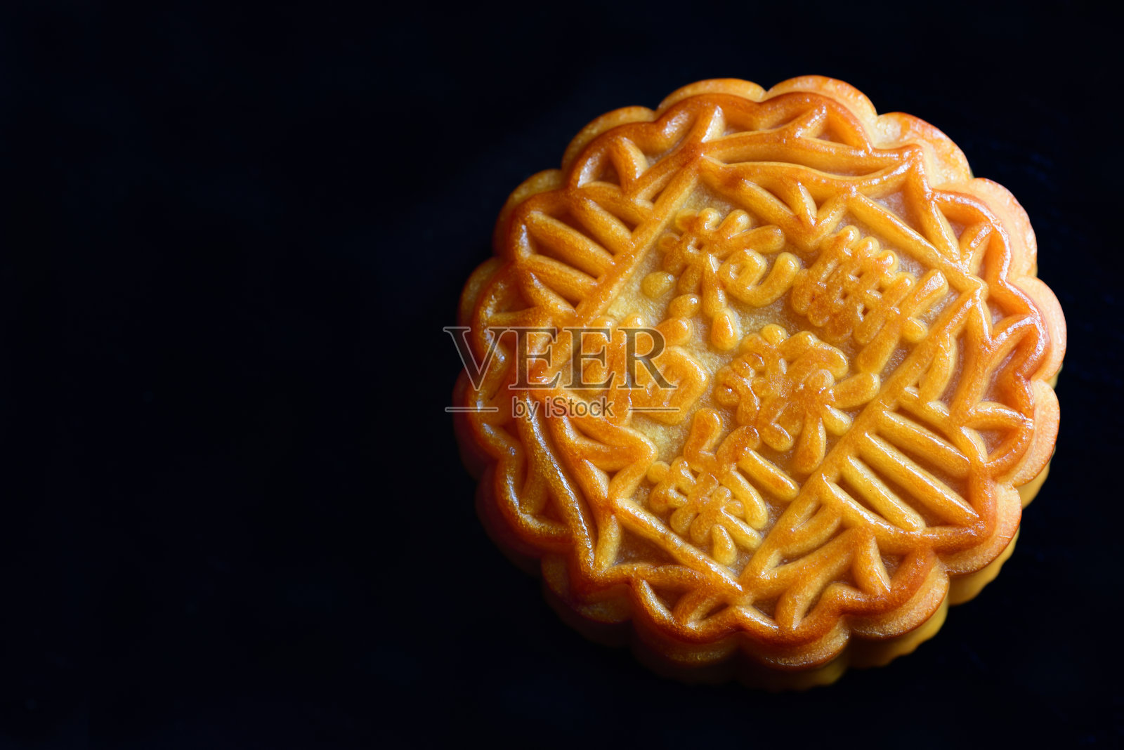 一个传统的中国月饼的特写，仍然是关闭的黑色背景与文字空间照片摄影图片