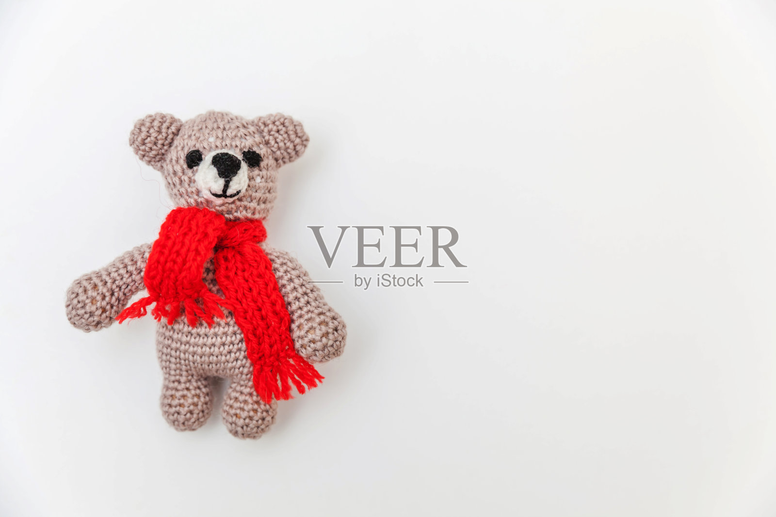 简单的最小设计，红色围巾的玩具熊孤立在白色的背景。儿童关爱母性家庭理念。平铺，俯视图，拷贝空间照片摄影图片