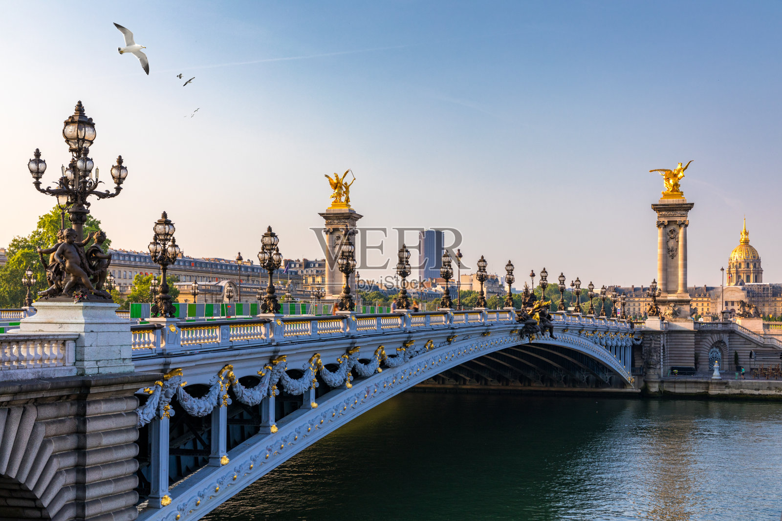 在阳光明媚的夏日早晨，亚历山大三世桥横跨塞纳河。装饰着华丽的新艺术派灯具和雕塑的桥。法国巴黎塞纳河上的亚历山大三世大桥。照片摄影图片