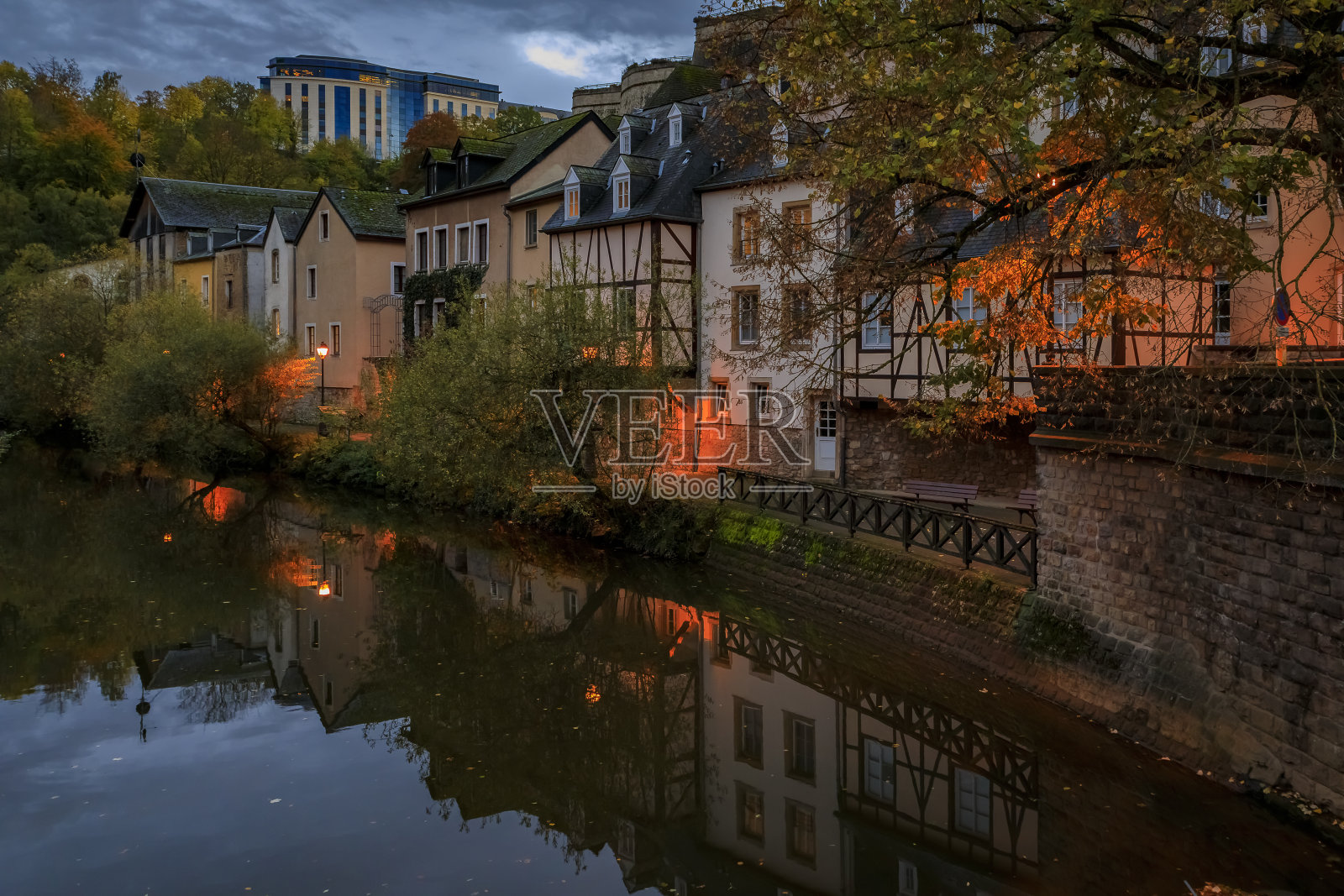 日落时分，在卢森堡老城区的阿尔泽特河上，联合国教科文组织世界遗产遗址和城墙上倒影着色彩柔和的房屋照片摄影图片