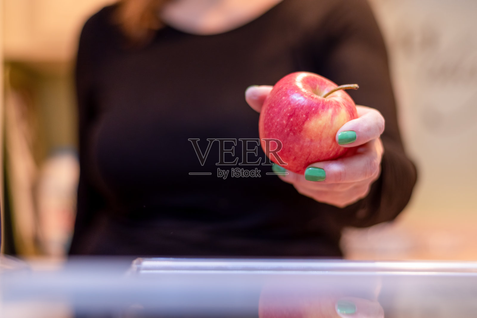 从冰箱里拿苹果的女人照片摄影图片