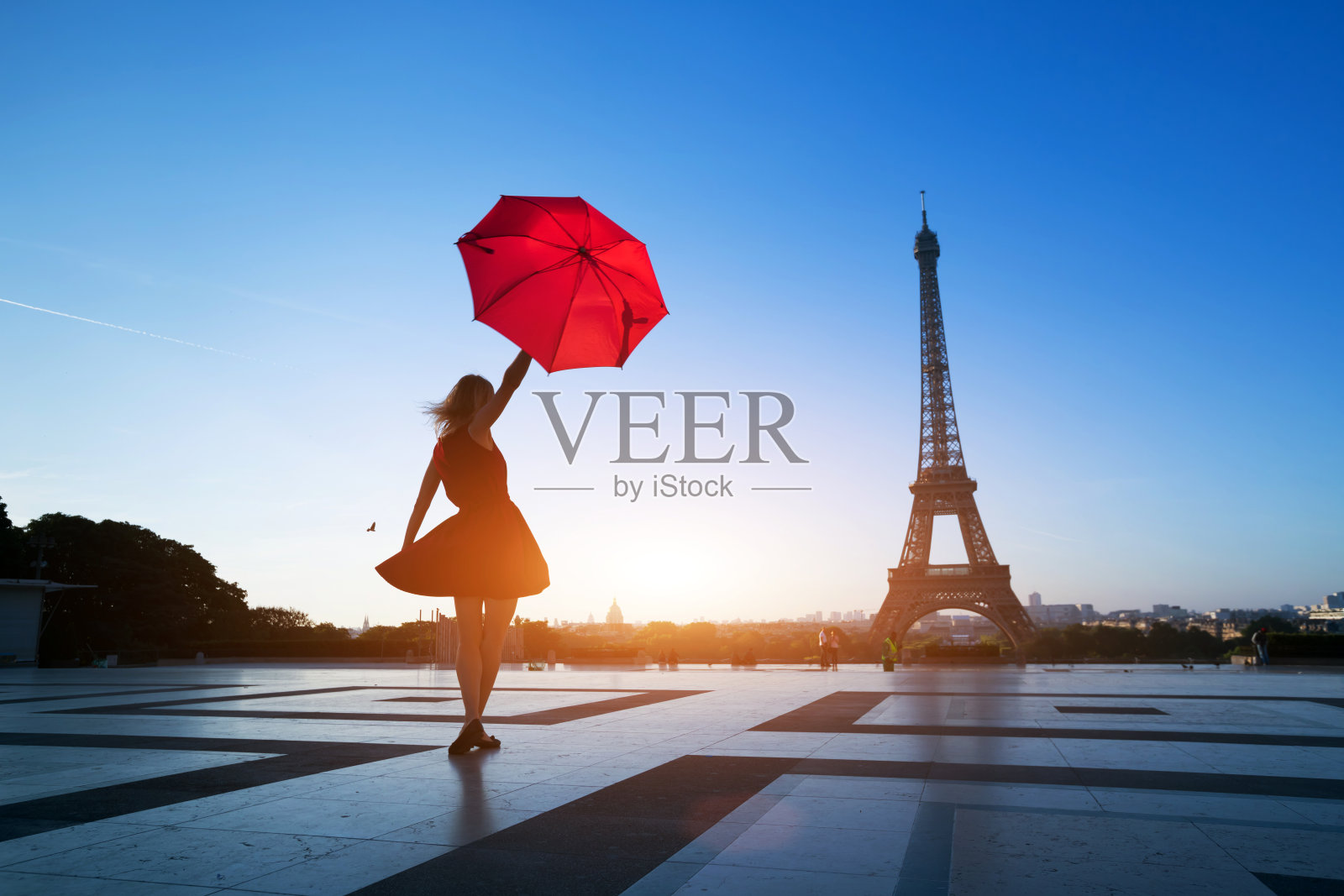 到巴黎旅游，在埃菲尔铁塔附近看到一个拿着红伞的女人的剪影照片摄影图片