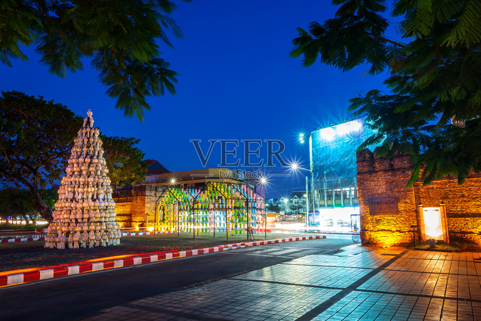 泰国清迈的夜晚，清迈门、古城、古城墙和护城河(昌福门)上的灯光在街道上摇曳。照片摄影图片