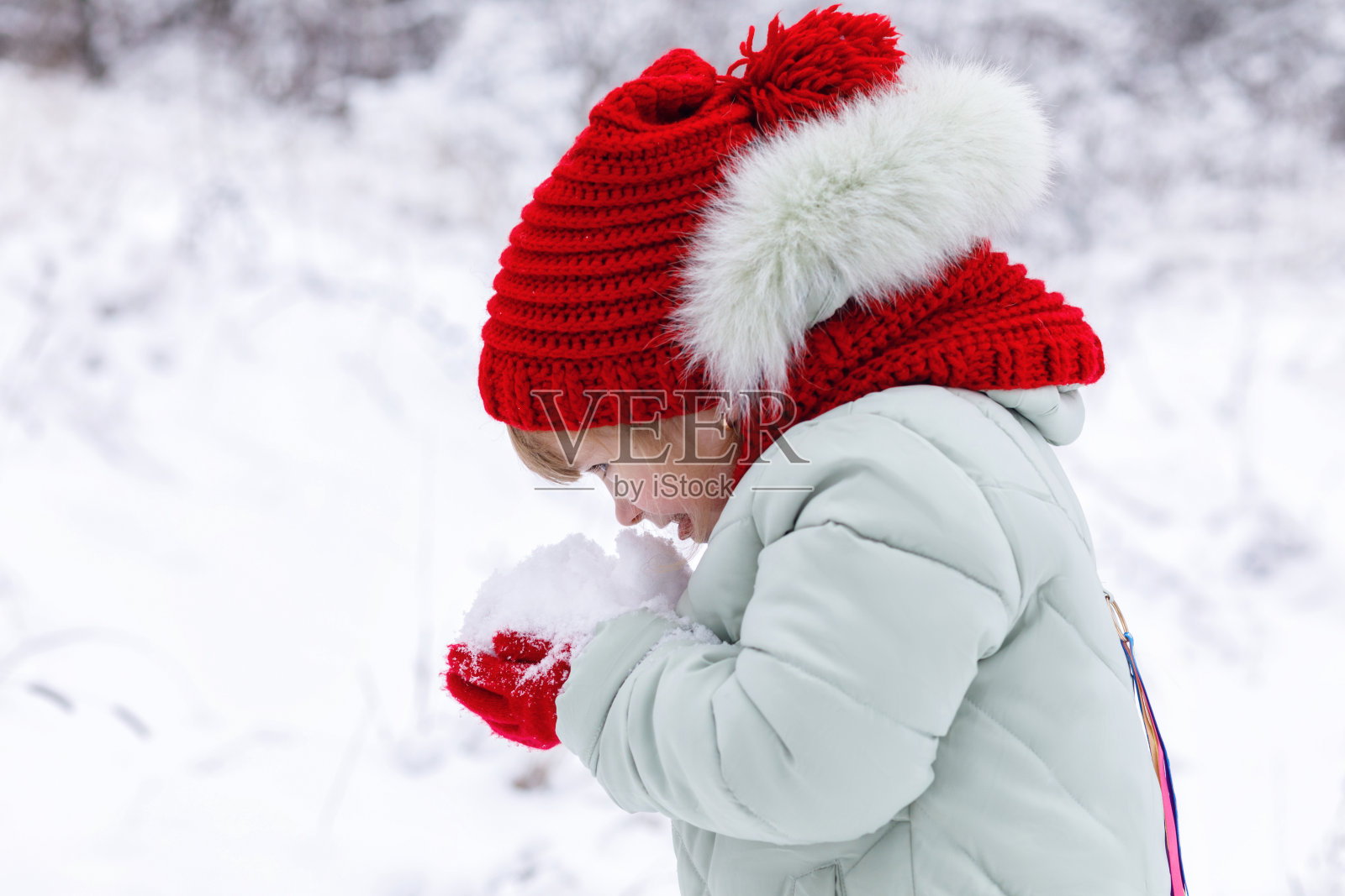 一个孩子手里拿着一堆雪。照片摄影图片