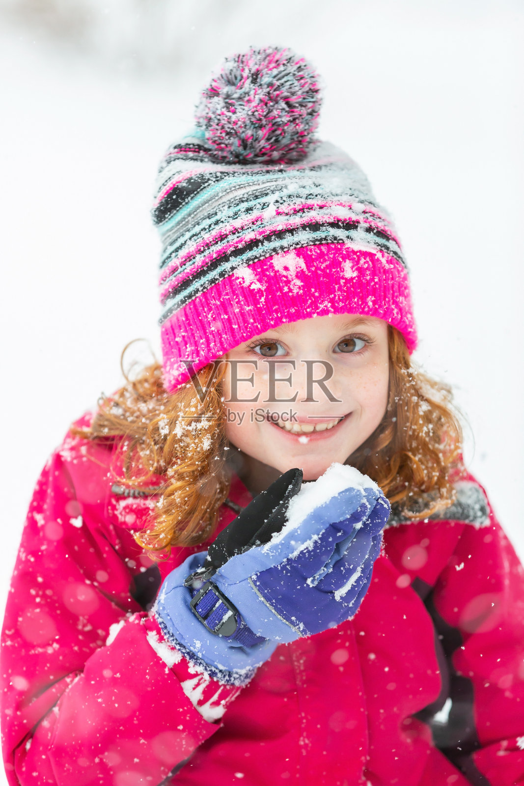 手里拿着雪的年轻女孩对着相机微笑照片摄影图片