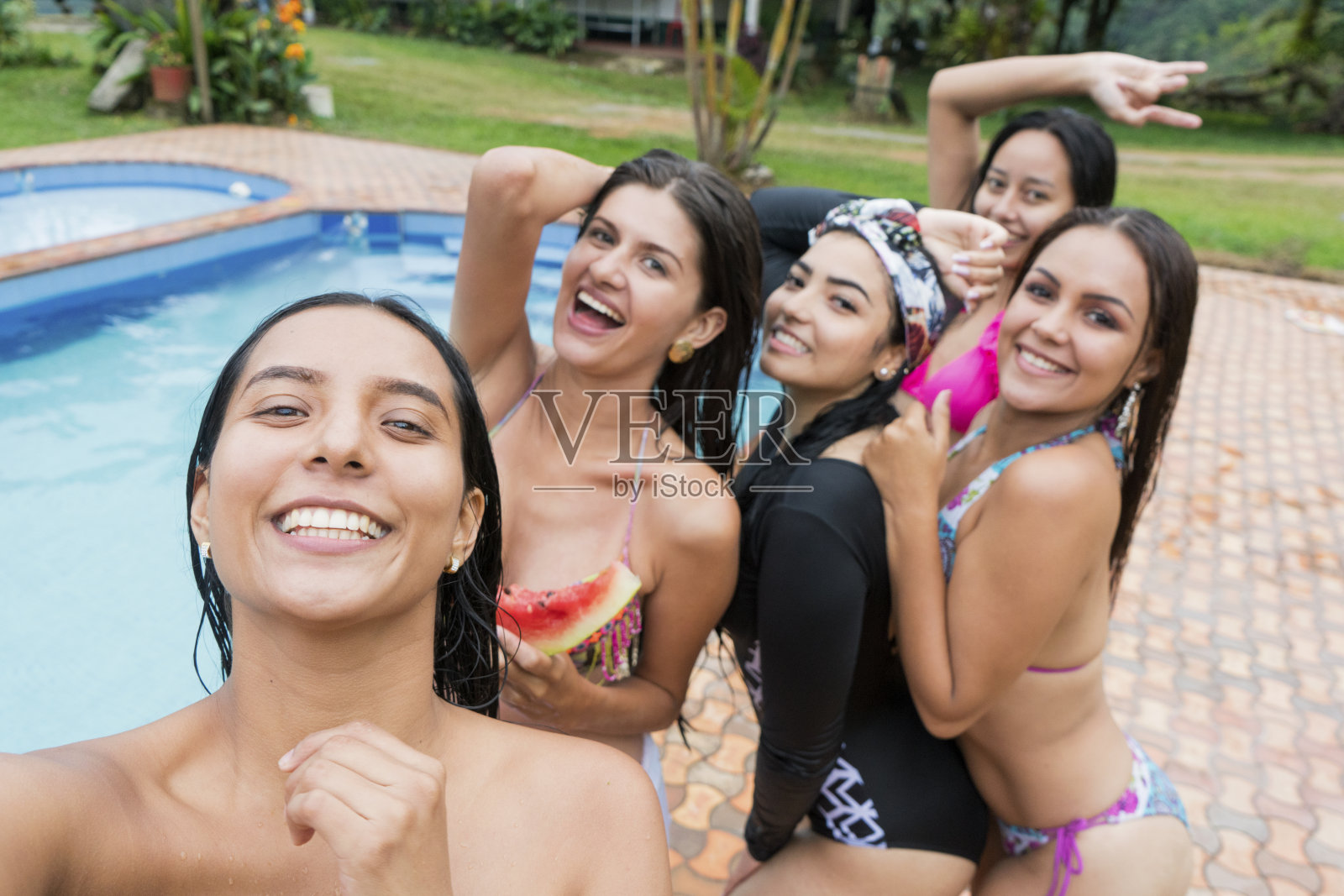 拉丁裔朋友拥抱游泳池的dentor笑的一刻的乐趣照片摄影图片