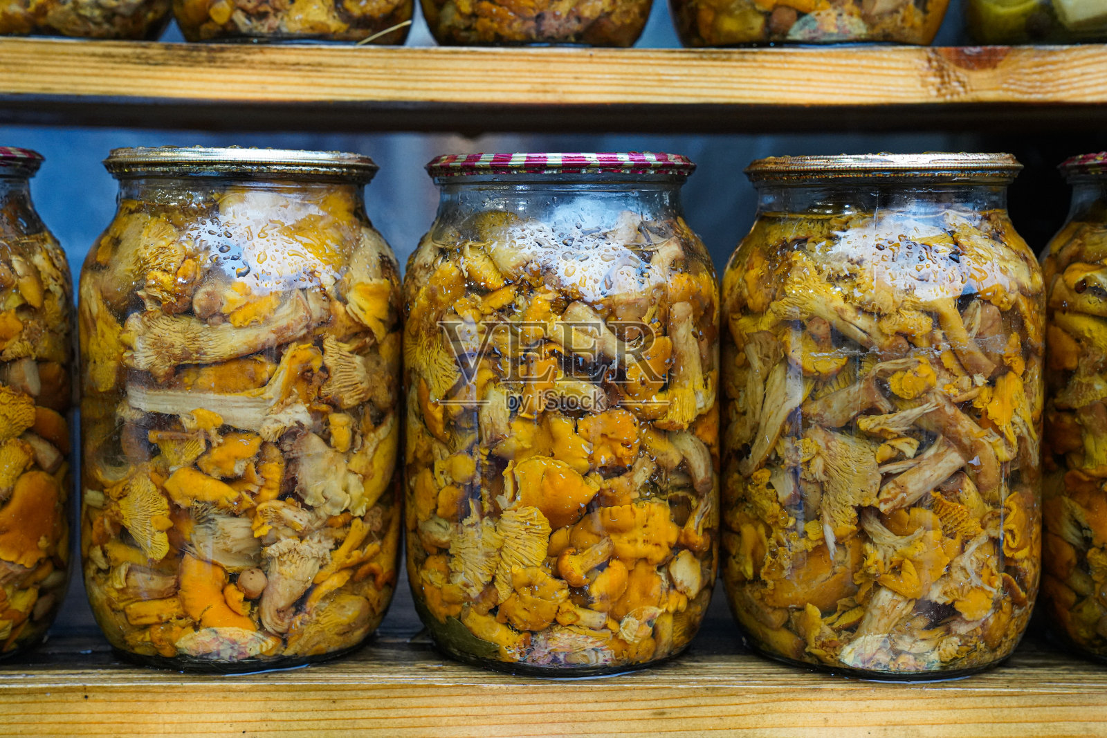 美味的棕色腌蘑菇在玻璃罐里合上，自制泡菜照片摄影图片