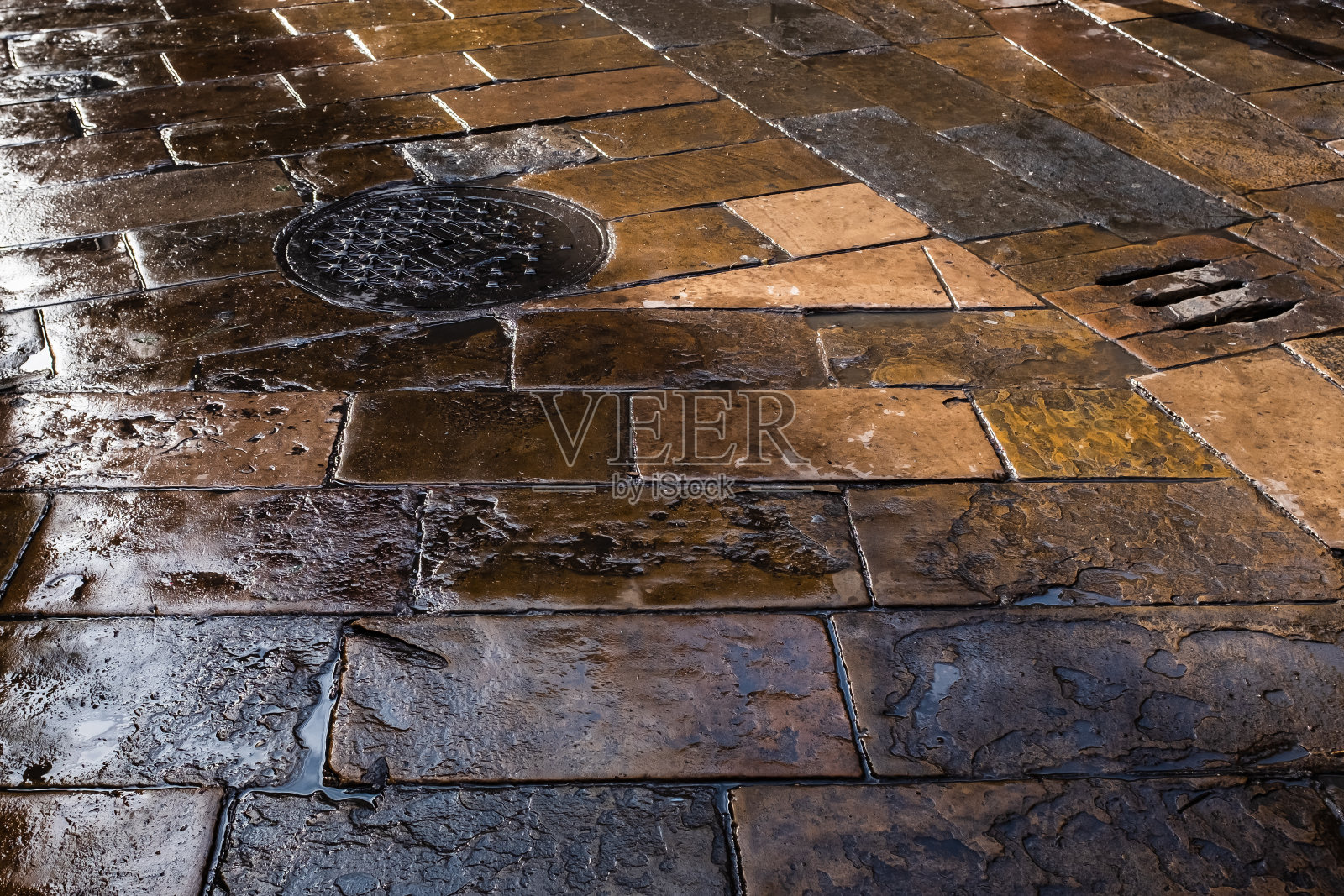 西班牙巴塞罗那Plaça del Pi(松树广场)潮湿的旧石铺地板。照片摄影图片