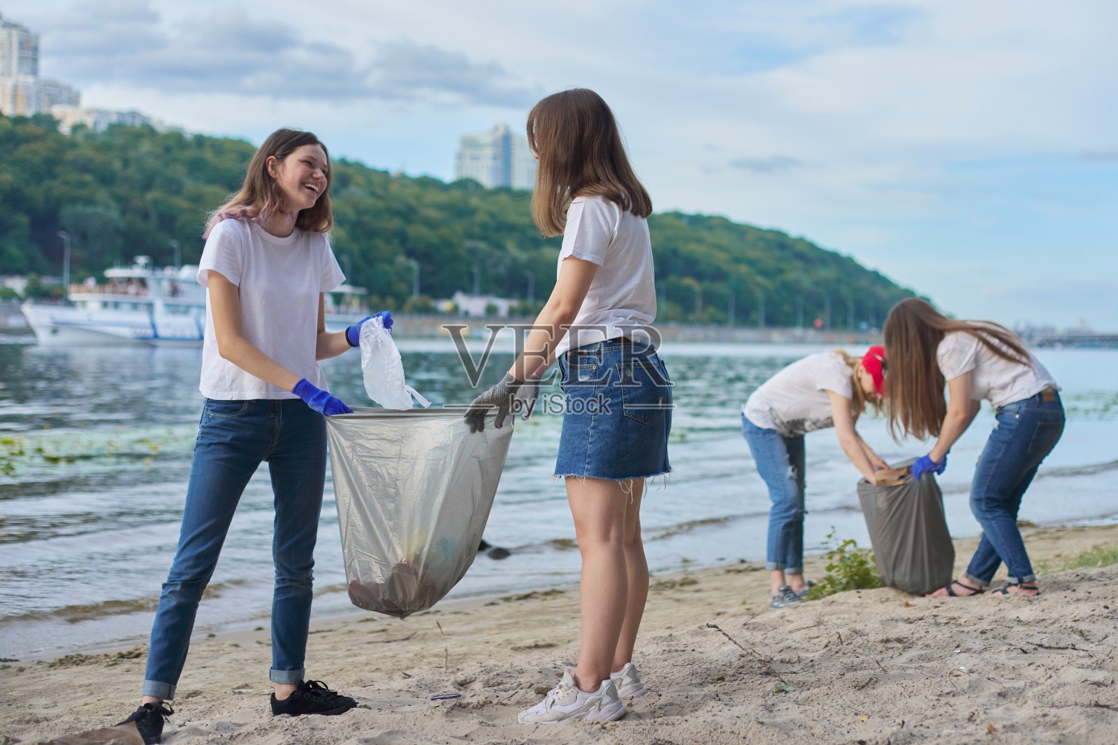 一组学生与老师在大自然中做塑料垃圾的清理工作照片摄影图片