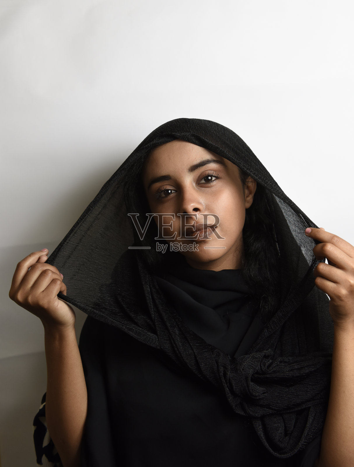 一个穆斯林女孩戴着白色的头巾。照片摄影图片