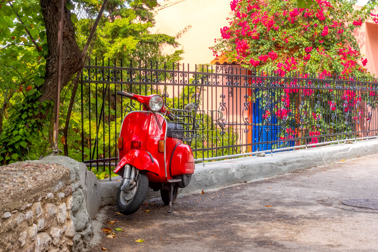 花园围栏上的红色滑板车照片摄影图片