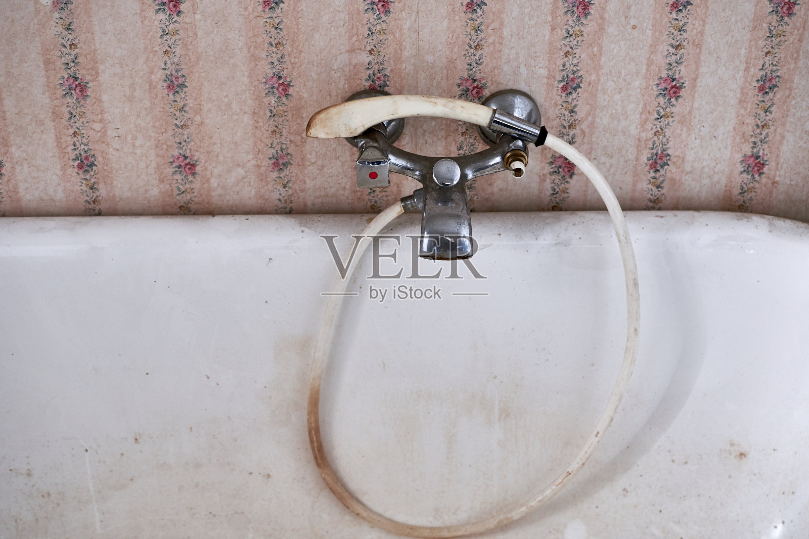 破旧的浴缸水龙头或带有脏乱的喷水管的水龙头照片摄影图片
