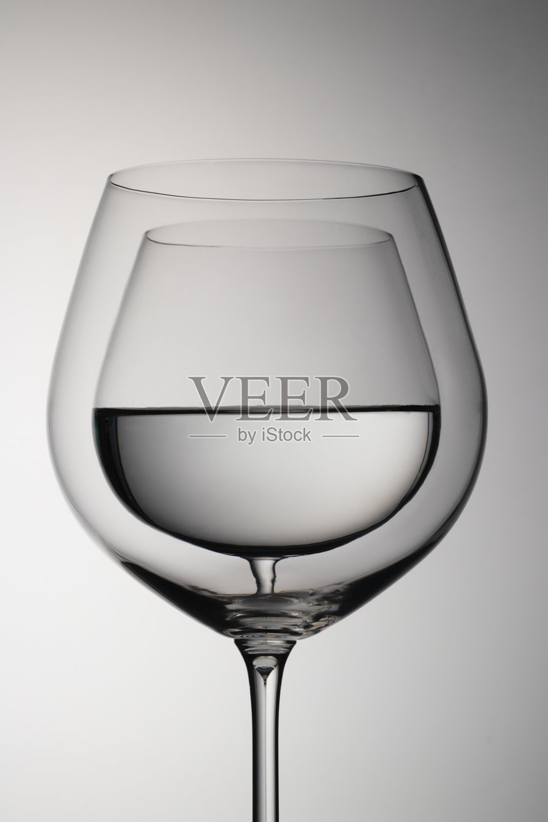 抽象的玻璃杯，杯子里装着水。照片摄影图片