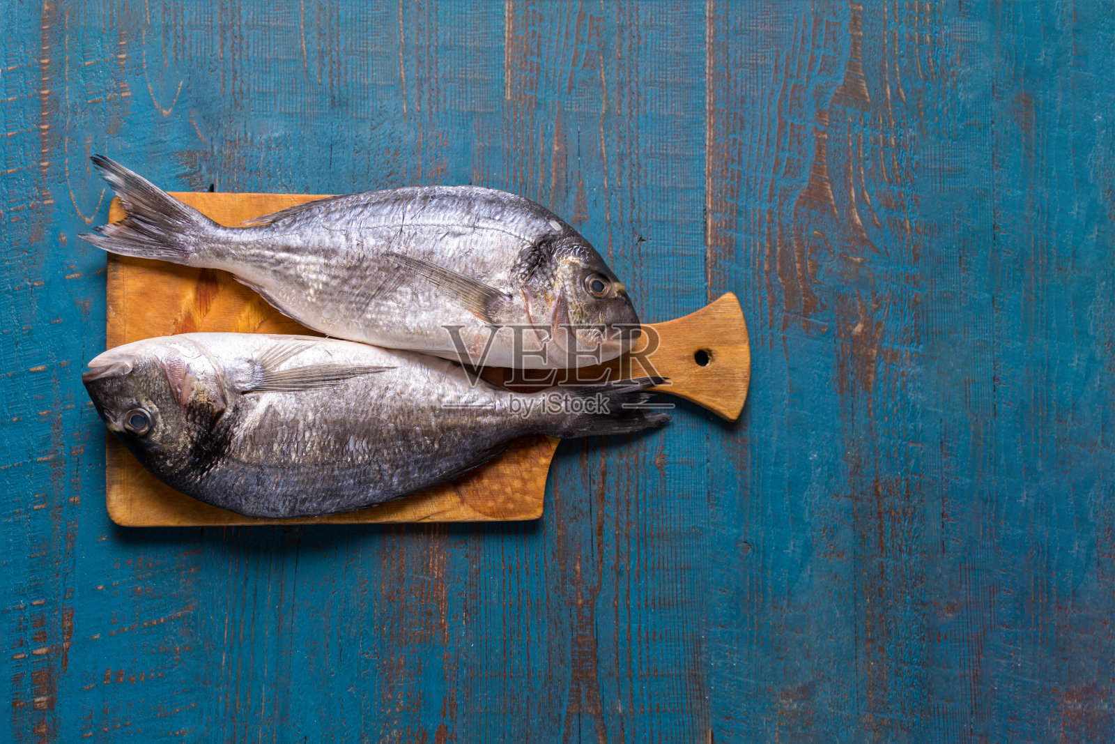 乡村风格。鱼的食物。鲱鱼在一个古老的蓝色木制背景和文本复制空间。照片摄影图片