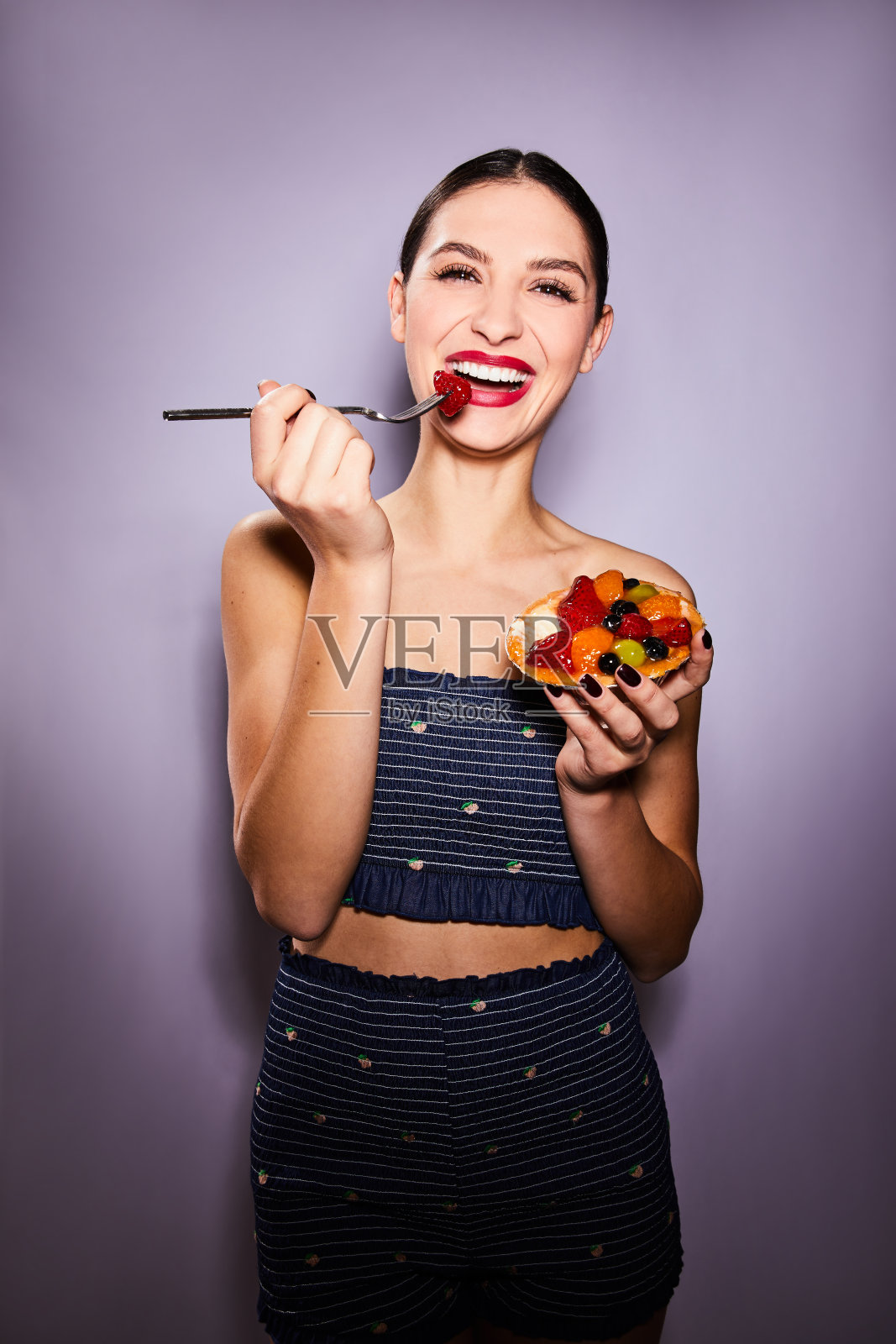 年轻女子笑着用叉子吃水果馅饼照片摄影图片