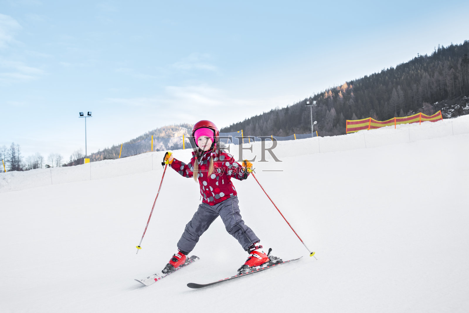 那孩子正在下山滑雪。照片摄影图片