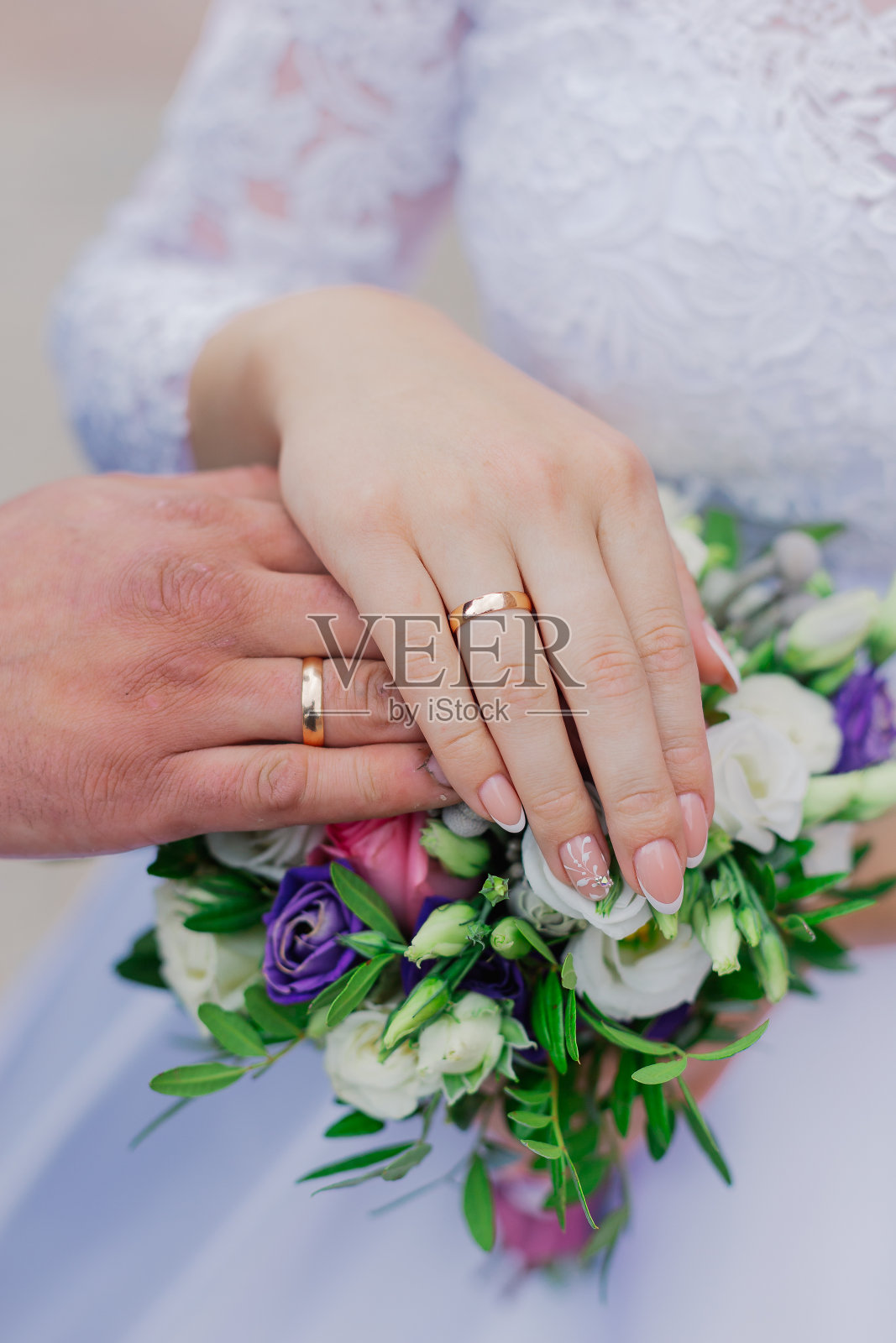 漂亮的手和新婚夫妇的结婚戒指在一个花束照片摄影图片
