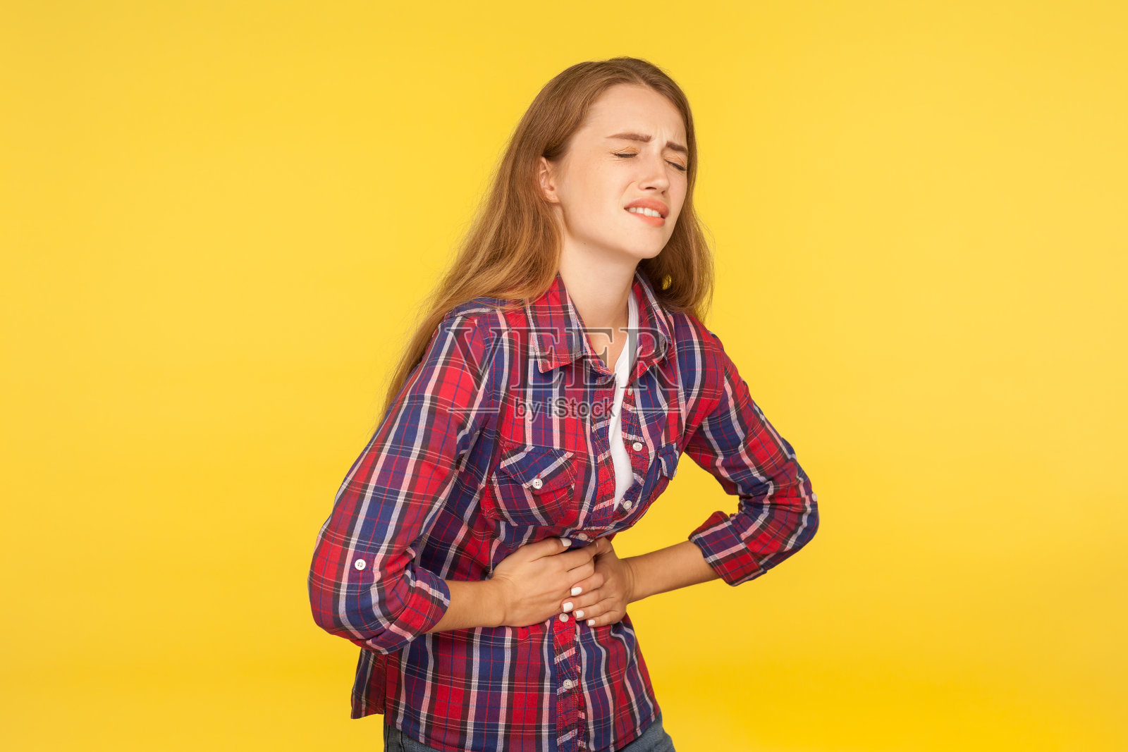 腹痛。肖像不健康的姜女孩在衬衫扣肚和遭受胃痛，消化不良的症状照片摄影图片