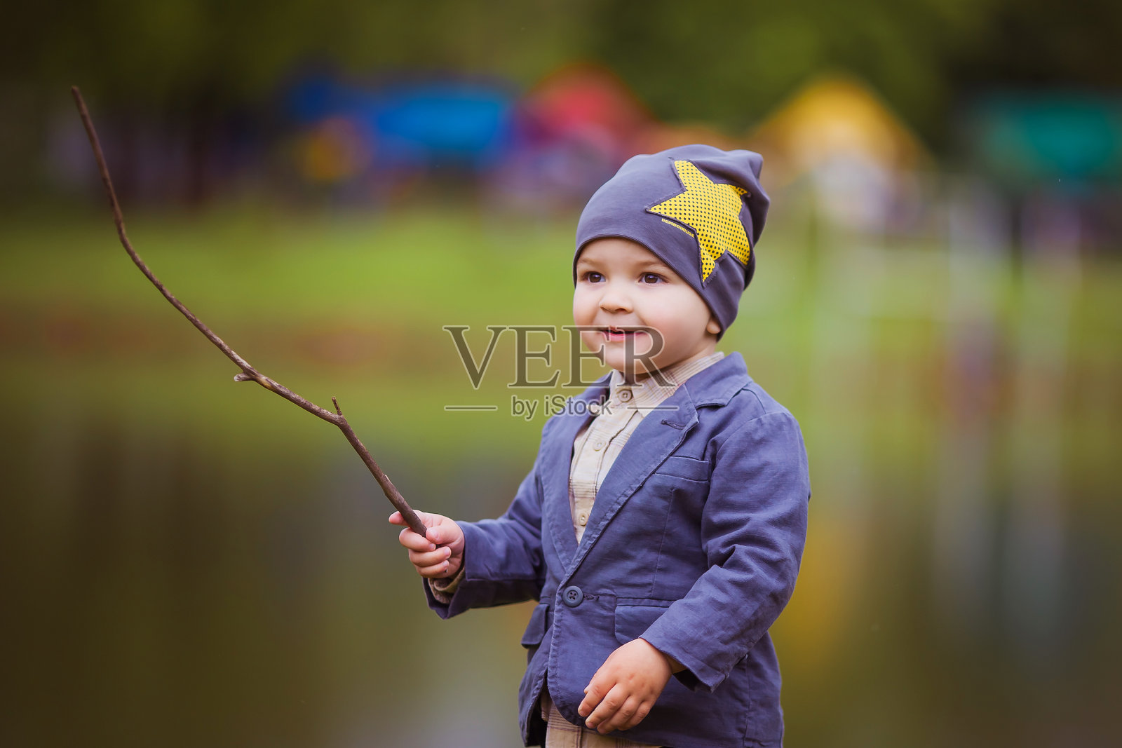 一个婴儿在河边玩木棍照片摄影图片