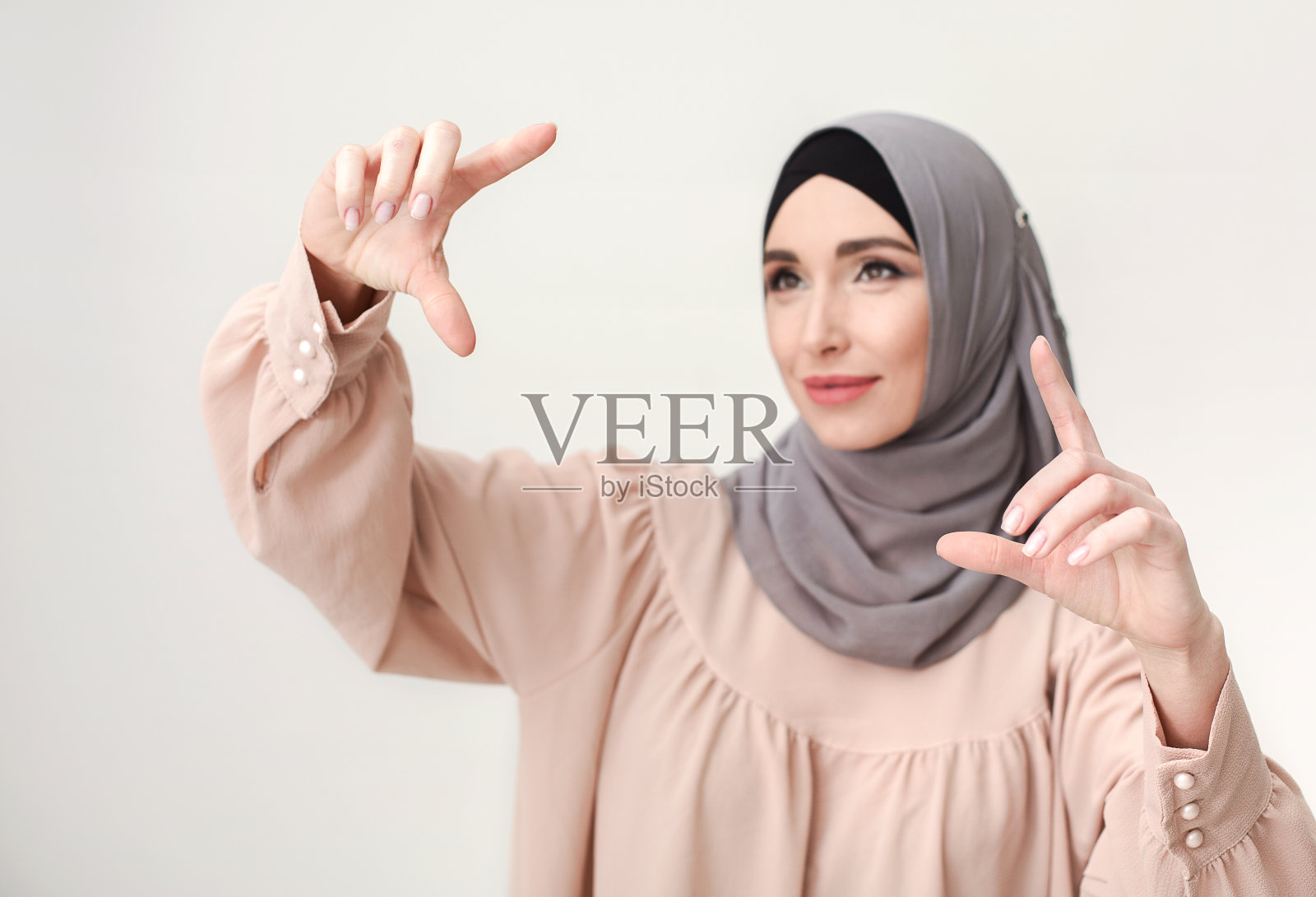 穆斯林妇女指着虚拟屏幕，拷贝空间照片摄影图片