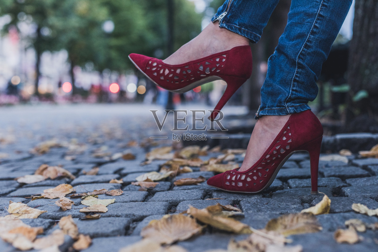 近距离观察秋天公园里的红色高跟鞋。照片摄影图片