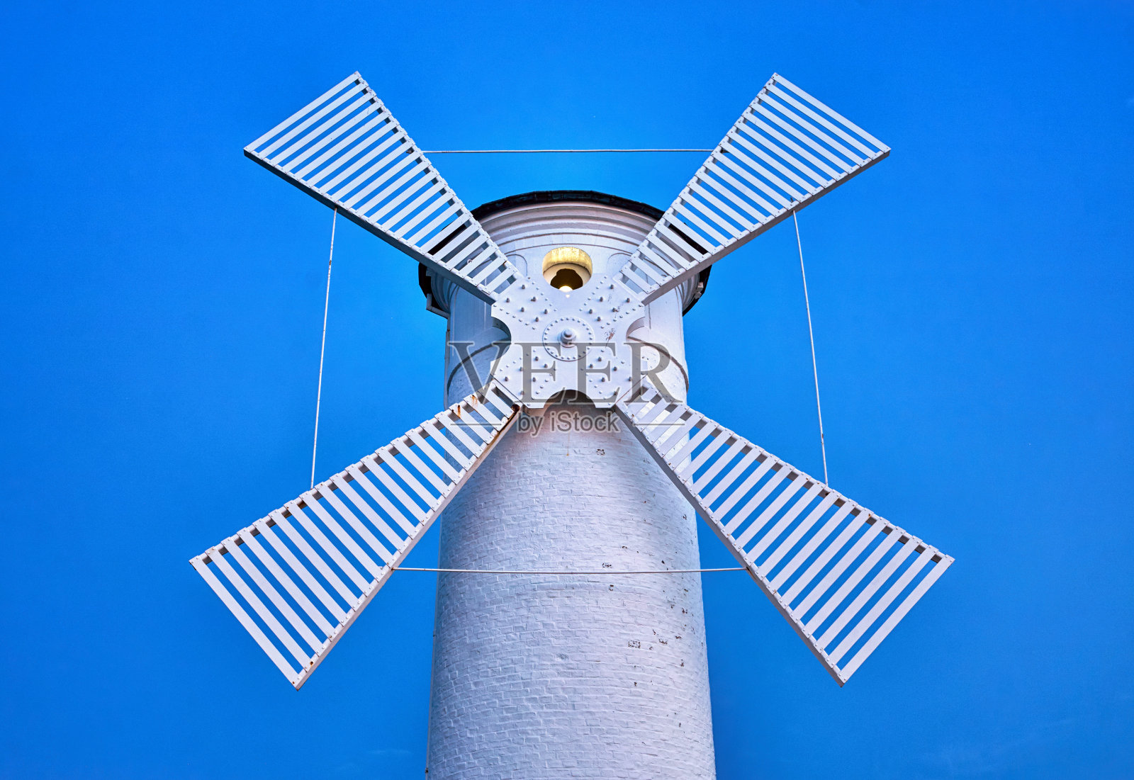 趋势色白色超现实的灯塔风车在蓝色的背景。照片摄影图片