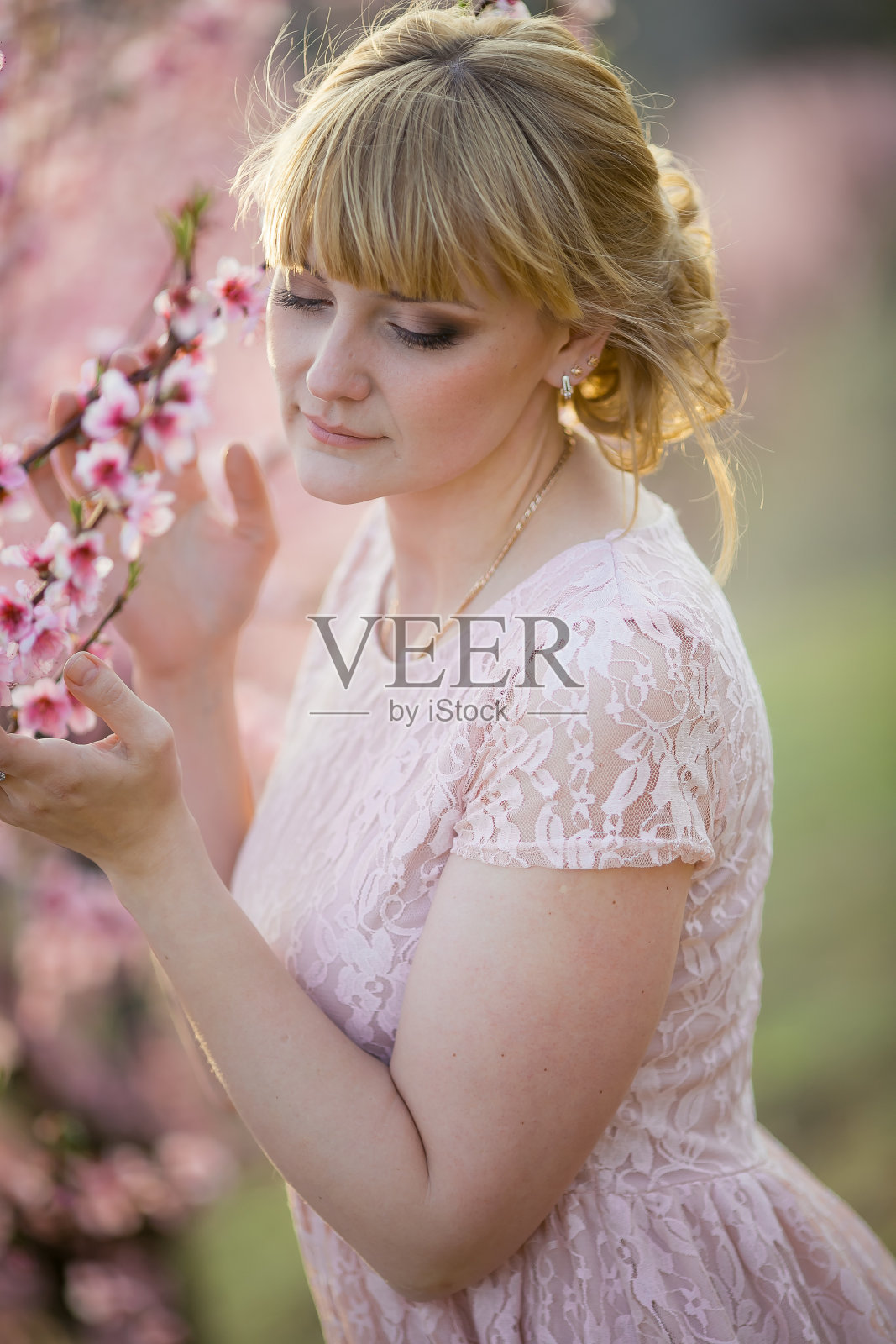 一名身穿粉色短裙的女子在花丛中漫步照片摄影图片