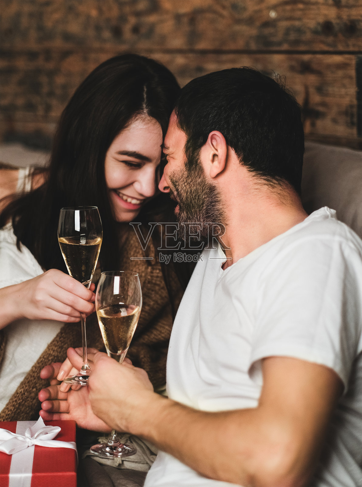 幸福微笑的夫妇在家里用香槟庆祝节日照片摄影图片
