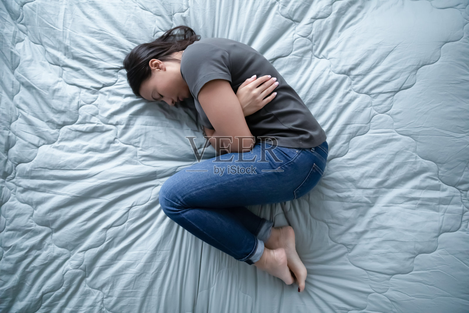 不健康的年轻女子躺在床上感到沮丧照片摄影图片