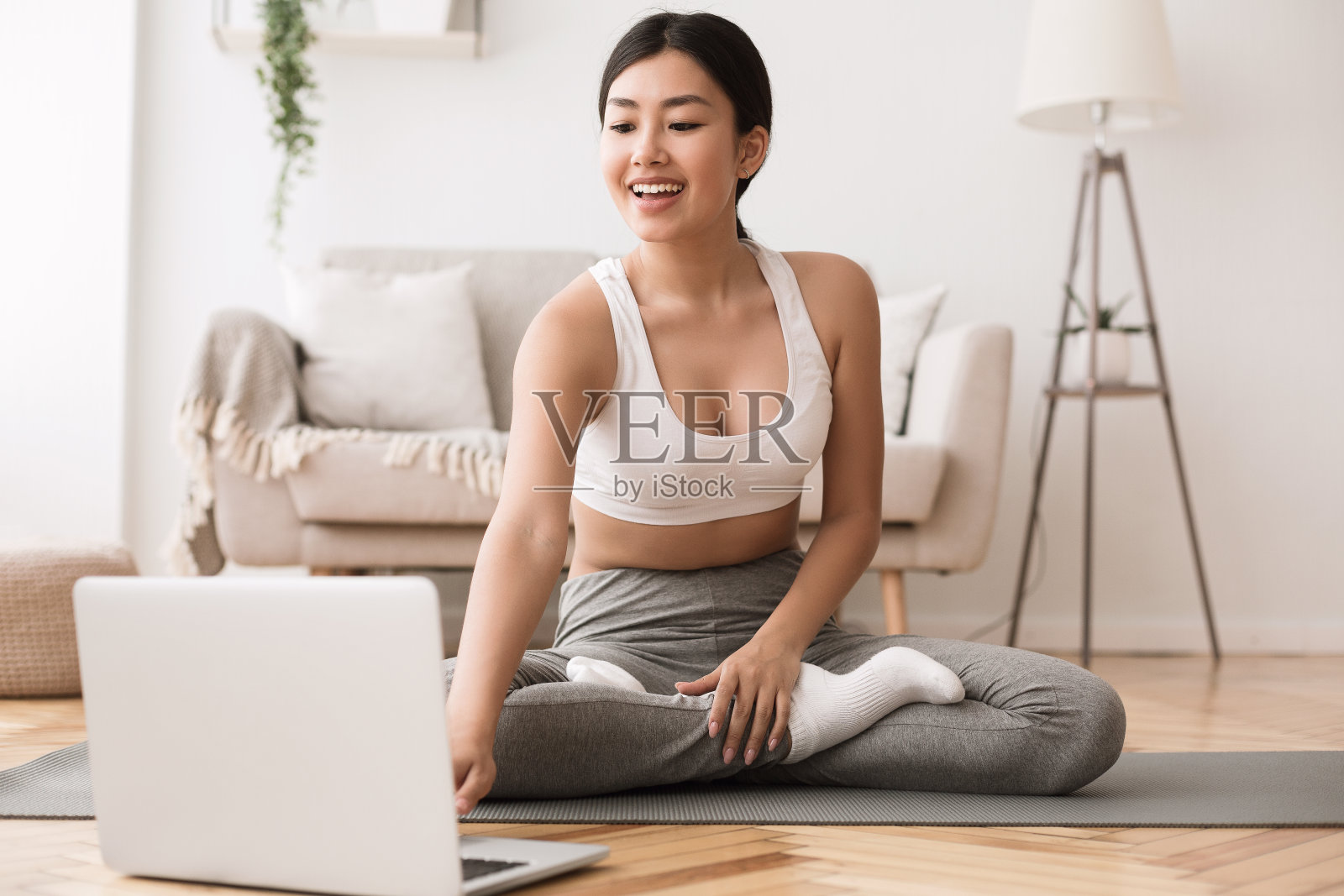 运动的应用程序。亚洲女孩练习瑜伽和使用笔记本电脑照片摄影图片