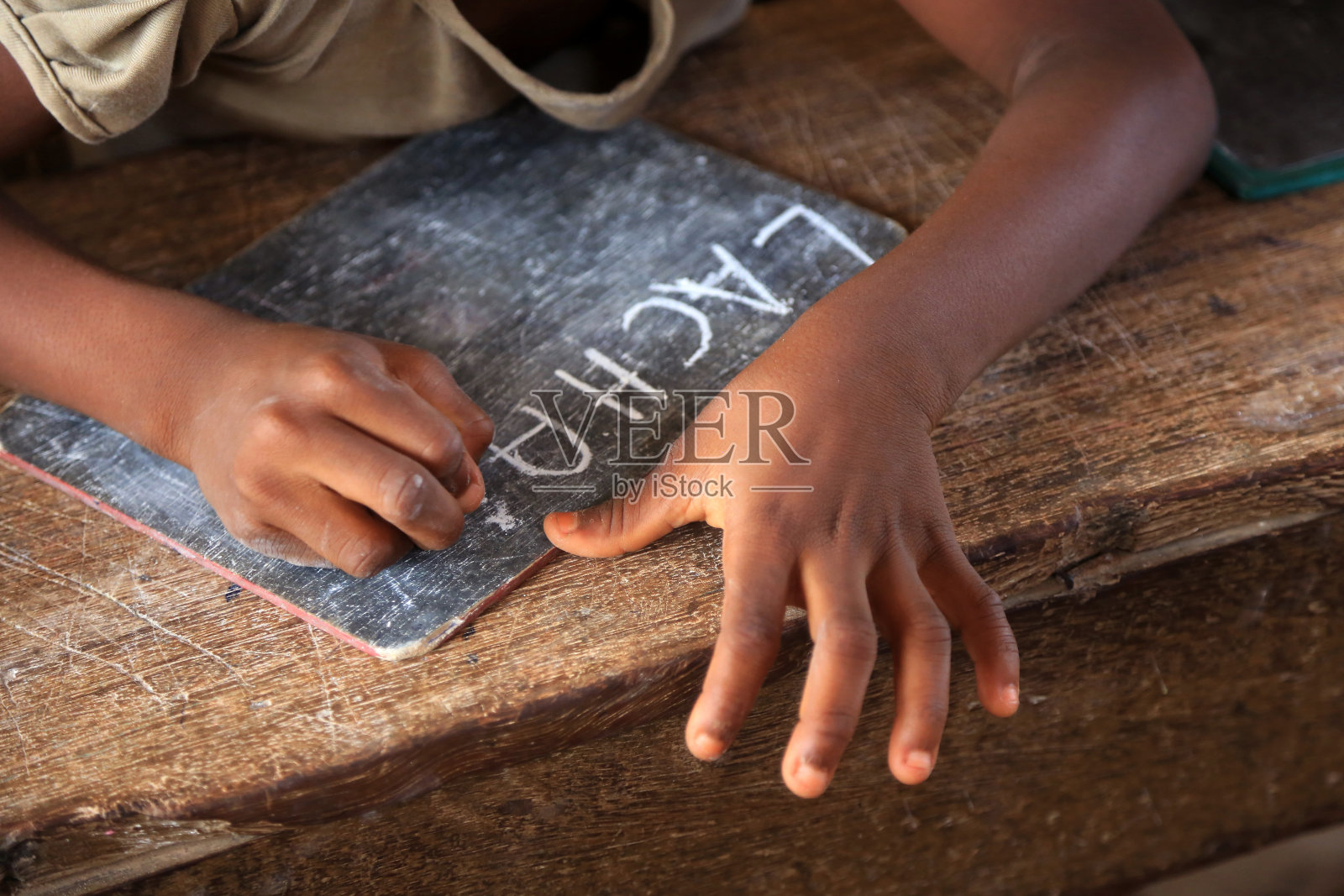 小学生在黑板上用粉笔写字。拼写课。洛美。多哥。西非。照片摄影图片