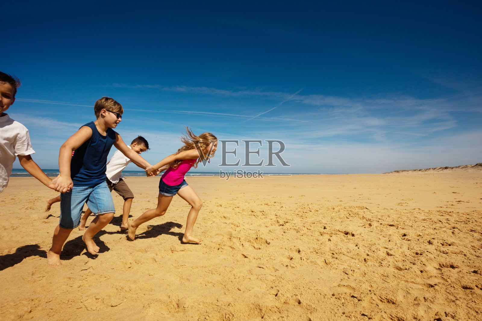 男孩和女孩在沙滩上奔跑照片摄影图片