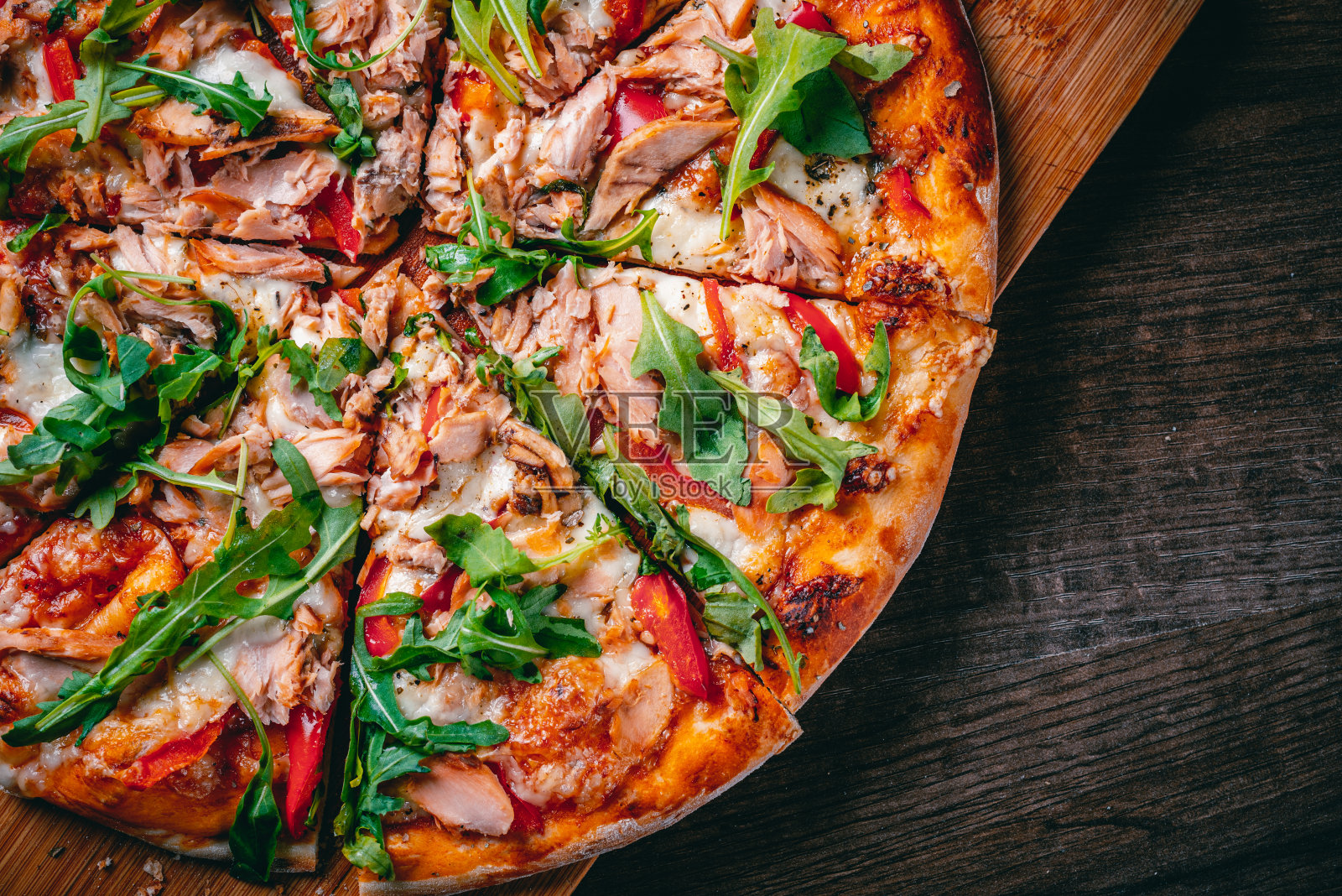 披萨配马苏里拉芝士，鲑鱼，番茄酱，胡椒。木桌子上的意大利披萨照片摄影图片
