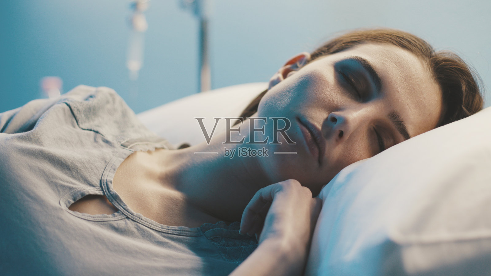 一个年轻女人晚上躺在医院的病床上照片摄影图片