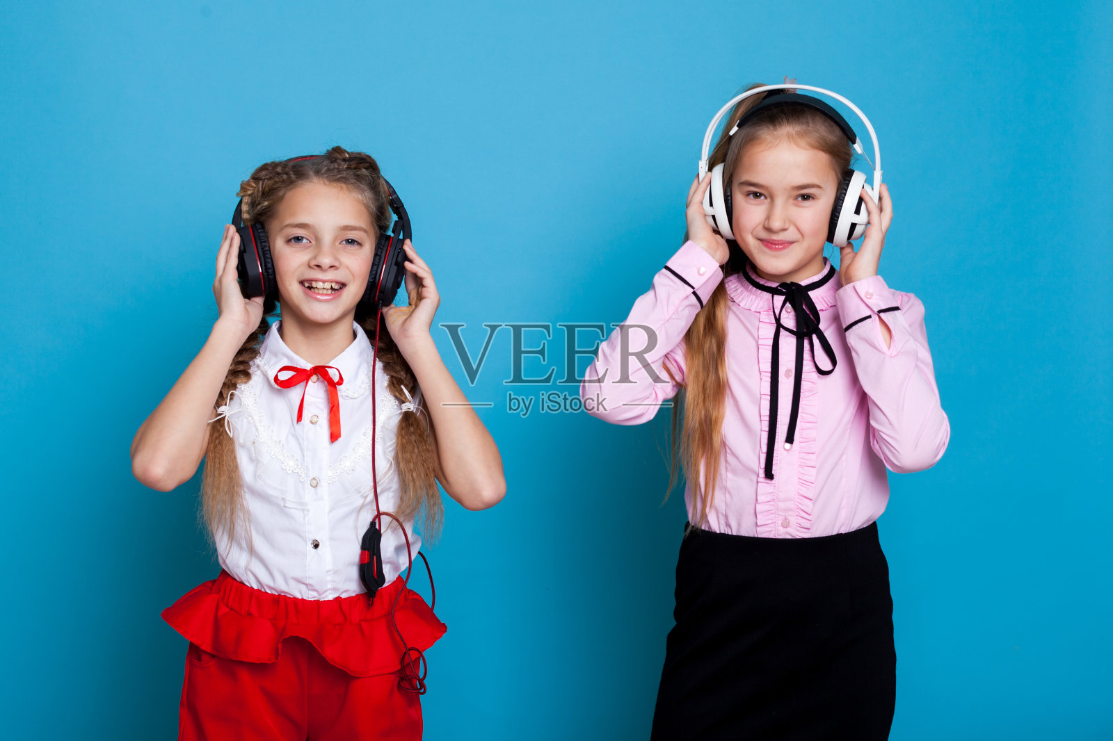 两个女学生一边戴着耳机听音乐一边跳舞照片摄影图片